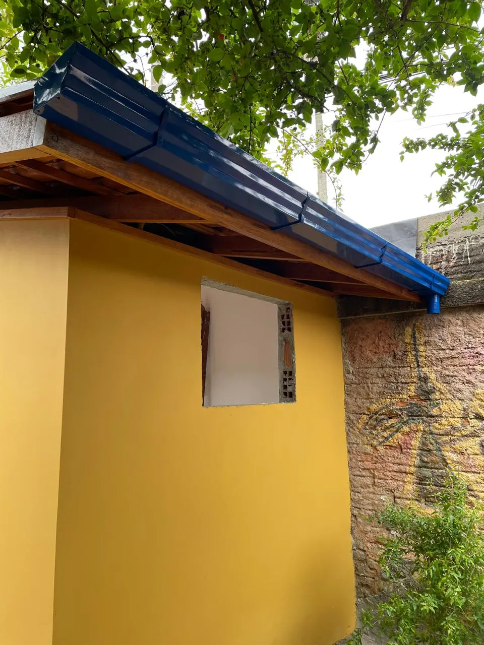 Calha azul instalada em casa amarela